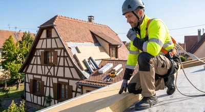 Photographie d'un artisan couvreur expérimenté, vêtu d'une tenue professionnelle de travail (veste haute visibilité et pantalon de chantier), inspectant ou examinant une toiture isolée par l'extérieur sur une maison individuelle. L'artisan regarde attentivement les travaux, incarnant l'expertise et la disponibilité. En arrière-plan, une maison résidentielle avec des travaux d'isolation visibles, matériaux de chantier organisés. Lumière naturelle, photographie réaliste de qualité professionnelle, environnement alsacien ou similaire, transmettant confiance et savoir-faire artisanal.